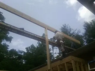 Carpenter setting a ridge beam over a new addition frame — Ice Dam Removal by Roofing Brothers in Cliffwood