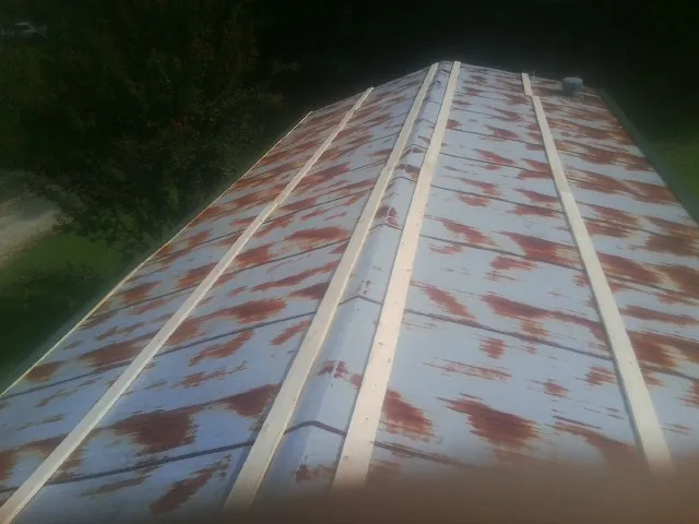 Rusted metal roof panels with new wood purlins before replacement — Storm Damage Roof Repair in Cliffwood by Roofing Brothers